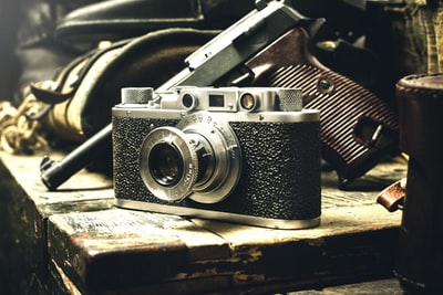 灰黑色桥牌相机和手枪的特写照片